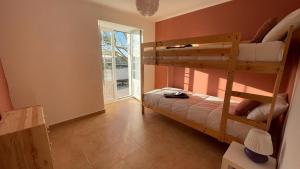 a bedroom with two bunk beds and a window at The Sunset Spot in São Bartolomeu