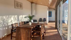 a dining room with a wooden table and chairs at The Sunset Spot in São Bartolomeu