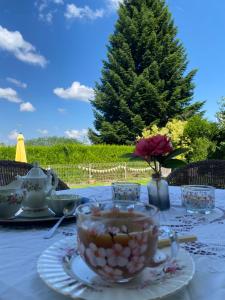a table with a cup of tea on top of it at Maison Blanche De Hudson in Cussac