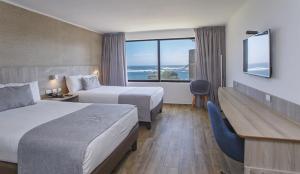 金特罗Yachting Hotel Quintero的有两张床和一扇大窗户的酒店房间