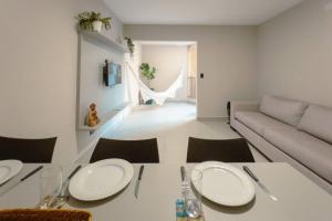 a white living room with a table and a couch at Apartamento Espaçoso Centro MJ22 in Maringá +19 photos