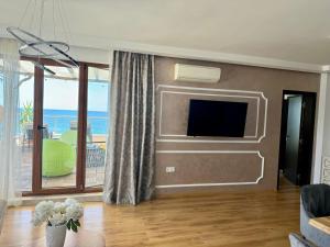 a living room with a flat screen tv on a wall at HPManagement Byala Beach Residence Apartments in Byala