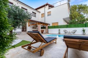a patio with a lounge chair and a swimming pool at Villa Antique in Novi Vinodolski
