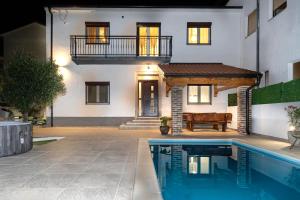 a house with a swimming pool in front of a house at Villa Antique in Novi Vinodolski