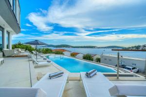 a swimming pool with lounge chairs and a view of the water at Villa Allina, 5-Bedroom Villa with Panoramic Views, Heated Pool in Podglavica
