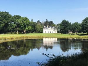 a large white house on a golf course with a lake at Les Hayes en Sologne - Proche Chambord in Fontaines-en-Sologne