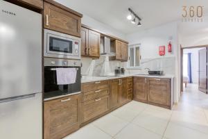 A kitchen or kitchenette at Charming & Central 3BR Apt with Private Terrace by 360 Estates