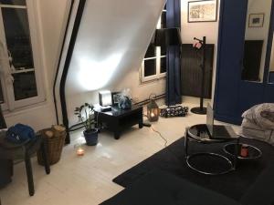 a living room with a couch and a table at Beau studio à Fontenay sous bois in Fontenay-sous-Bois