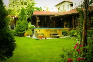 een huis met een tuin met groen gras bij Guest House Chicho Tsane in Bansko