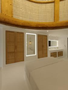 a room with a bed and some wooden cabinets at Yialos Ios Hotel in Ios Chora