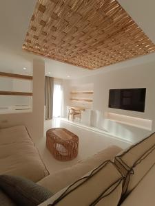 a living room with a couch and a flat screen tv at Yialos Ios Hotel in Ios Chora