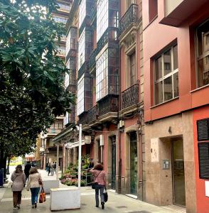 un grupo de personas caminando por una calle de la ciudad en EL ENCANTO DEL CENTRO, en Gijón