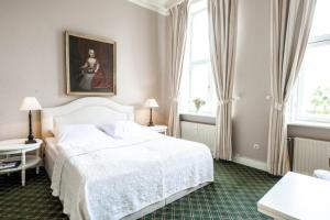 a bedroom with a white bed and a painting on the wall at Herrenhaus Appartement 4 in Lüdersburg