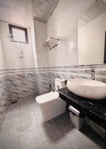 ein Badezimmer mit Waschbecken, Toilette und Spiegel in der Unterkunft Khách Sạn Metro Ban Mê in Buon Ma Thuot + 17 Fotos