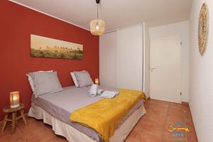 a bedroom with a bed with a red wall at Superbe Nid Douillet avec Terrasse, Double Parking in Carcassonne +18 photos