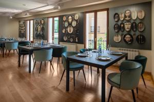 a restaurant with black tables and green chairs at Hotel-Boutique by Gonzalo Sesma in Cervera del Río Alhama