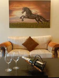 a table with two wine glasses and a painting of a horse at Spacious Apart, 2-min to beach & Old Souk in Jbeil