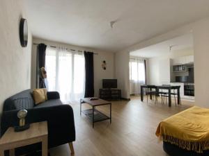 una sala de estar con un sofá y una mesa en Joli T4 avec balcon, place de parking - Oradou, en Clermont-Ferrand