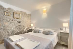 Un dormitorio con una cama y una pared de piedra. en Beautiful Villa Cartolina with pool in Buje, en Krasica 32 fotos más