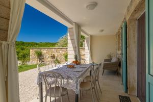 Un comedor con mesa y sillas en un patio. en Beautiful Villa Cartolina with pool in Buje, en Krasica