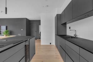 a kitchen with black and white cabinets and a wooden floor at The Arctic Urban Cityscape in Tromsø