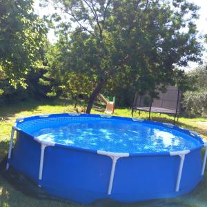 a large blue pool with a chair in a yard at WOODEN HOUSE in Preveza