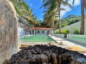 a house with a swimming pool with palm trees at SaoConDor Hotel in Con Dao