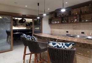 a bar with chairs and a counter in a restaurant at Amyth of Mykonos Super Paradise in Super Paradise Beach