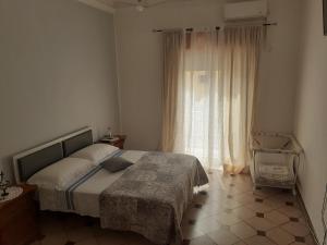 una camera da letto con un letto e una grande finestra di Casa dello Scoglio nel mare a Paceco