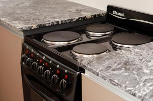 a black stove top oven with a granite counter top at N3 - Irigoyen 2 in Villa Constitución