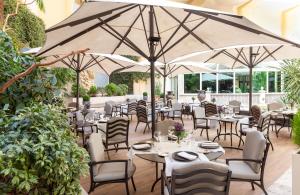 a restaurant with tables and chairs and umbrellas at InterContinental Madrid, an IHG Hotel in Madrid