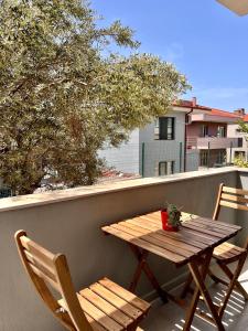 a wooden table and two chairs on a balcony at BiSuite Urla in Kuscular