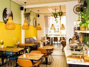 a restaurant with tables and chairs and pendant lights at ApartHotel Waepen van Middelburg in Middelburg