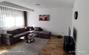 a living room with a couch and a television at Green Apartment! in Prishtinë