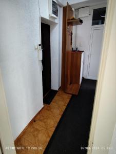 a hallway of a room with a door and a kitchen at Green Apartment! in Prishtinë +4 photos