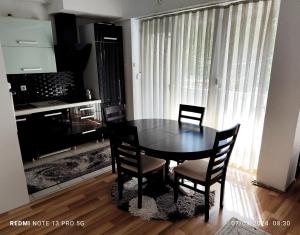 a dining room table and chairs in a room at Green Apartment! in Prishtinë
