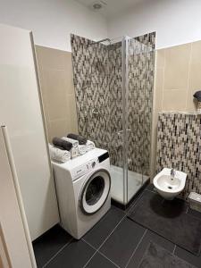 a bathroom with a washing machine and a sink at Favoriten Apartments in Vienna