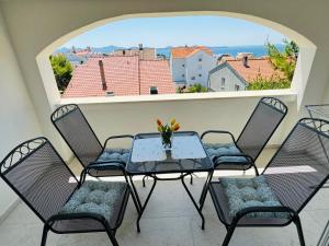 Una mesa y sillas en un balcón con vista. en Apartments & Rooms Petra, en Zadar