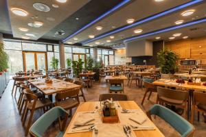 un ristorante con tavoli e sedie in legno e finestre di Hotel Ramonda a Boljevac