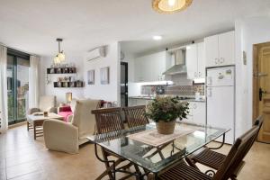 Una cocina y una sala de estar con una mesa de cristal y sillas. en Bella Vistas, en Zahara de los Atunes