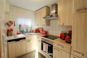 a small kitchen with wooden cabinets and a sink at Fischlandhus in Dierhagen