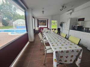 a dining room with a table and chairs and a pool at habitaciones en Chalet con piscina y jacuzzi en Madrid in Algete