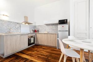 a kitchen with a table and a white table and chairs at appartement 2 pièces Jean Macé et stationnement in Lyon +2 photos