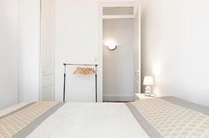 a white bedroom with a bed and a door at appartement 2 pièces Jean Macé et stationnement in Lyon