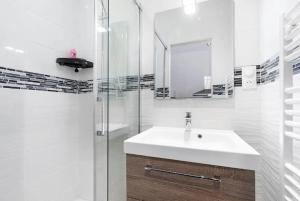 a white bathroom with a sink and a shower at appartement 2 pièces Jean Macé et stationnement in Lyon