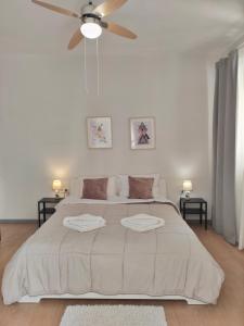 ein weißes Schlafzimmer mit einem großen Bett und einem Deckenventilator in der Unterkunft Apartment A1 in Kalamata + 11 Fotos
