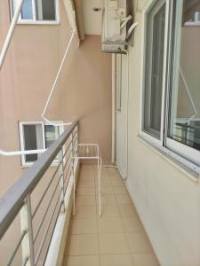 einen Balkon mit einem Stuhl und einem Fenster in der Unterkunft Apartment A1 in Kalamata