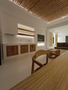 a living room with a table and a chair at Yialos Ios Hotel in Ios Chora