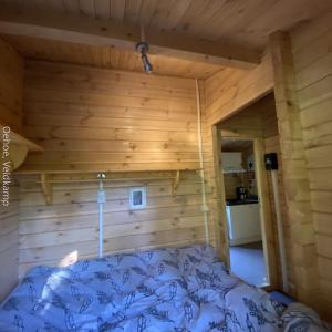a bedroom with a bed in a wooden room at Rust en Natuur in Ons Vrijstaande Fins Chalet in Epe +18 photos