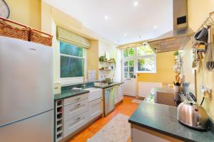 a large kitchen with white appliances and yellow walls at Tarn House in Elterwater